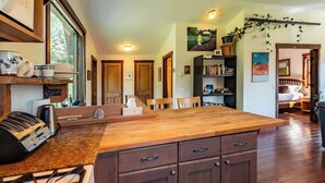 A kitchen with a central island, wooden cabinets, and a gas stove.