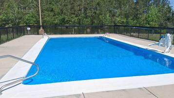 En säsongsöppen utomhuspool, parasoller och solstolar