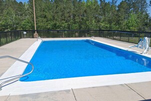 Una piscina al aire libre de temporada, sombrillas