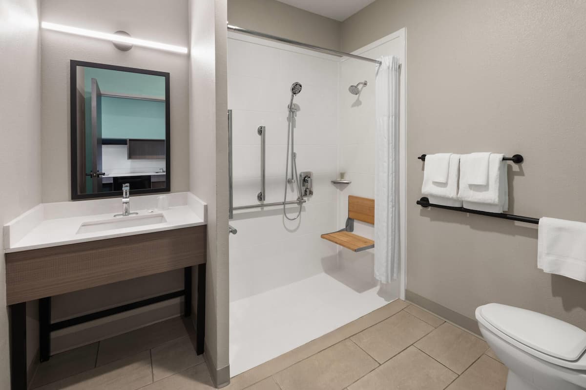 A bathroom with a shower, toilet, and sink.