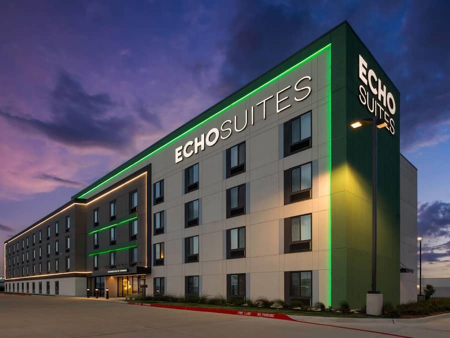 A hotel with a modern facade, multiple floors, and a prominent signage for 'ECHO SUITES.'
