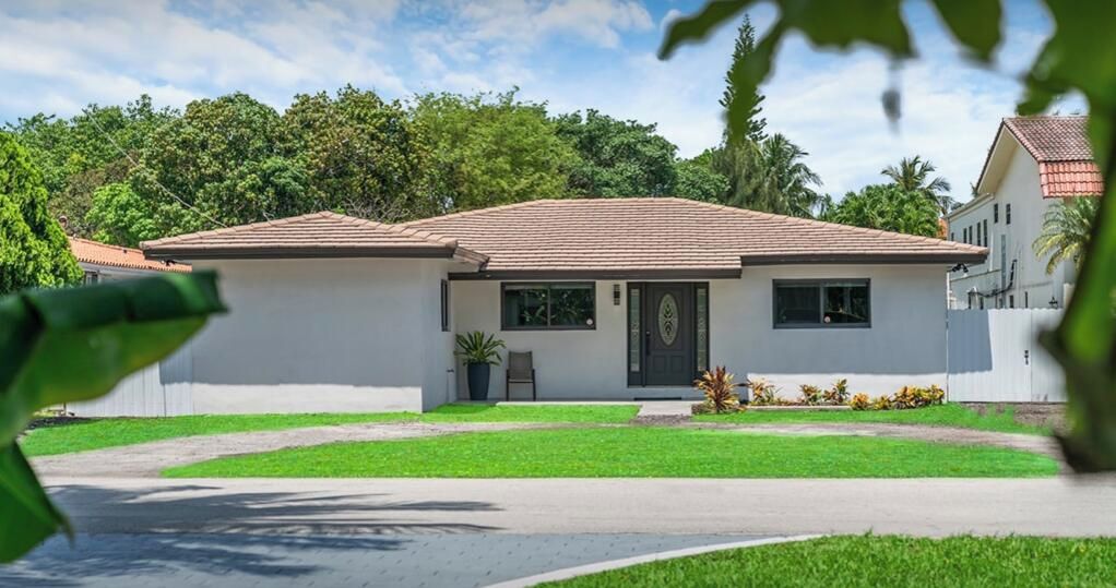 Une maison de plain-pied avec un toit en tuiles, un porche à l’avant et un petit jardin.