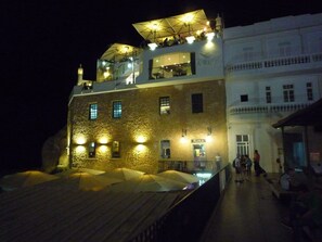 A building with a stone facade, multiple windows, and a sign reading "RUINA".