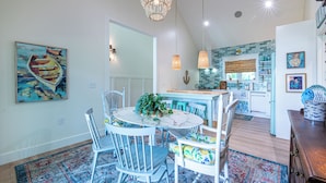 A dining area with a round table, white chairs, and a blue patterned rug. - Charming 3-beds with loft in peaceful cove on Watts Bar Lake! Bring your boat! (Ten Mile)