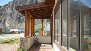A modern building with a wooden porch and large windows. - Condor de los Andes (El Chalten)