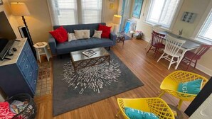 Ein Wohnzimmer mit einer Couch, einem Couchtisch und gelben Sesseln.