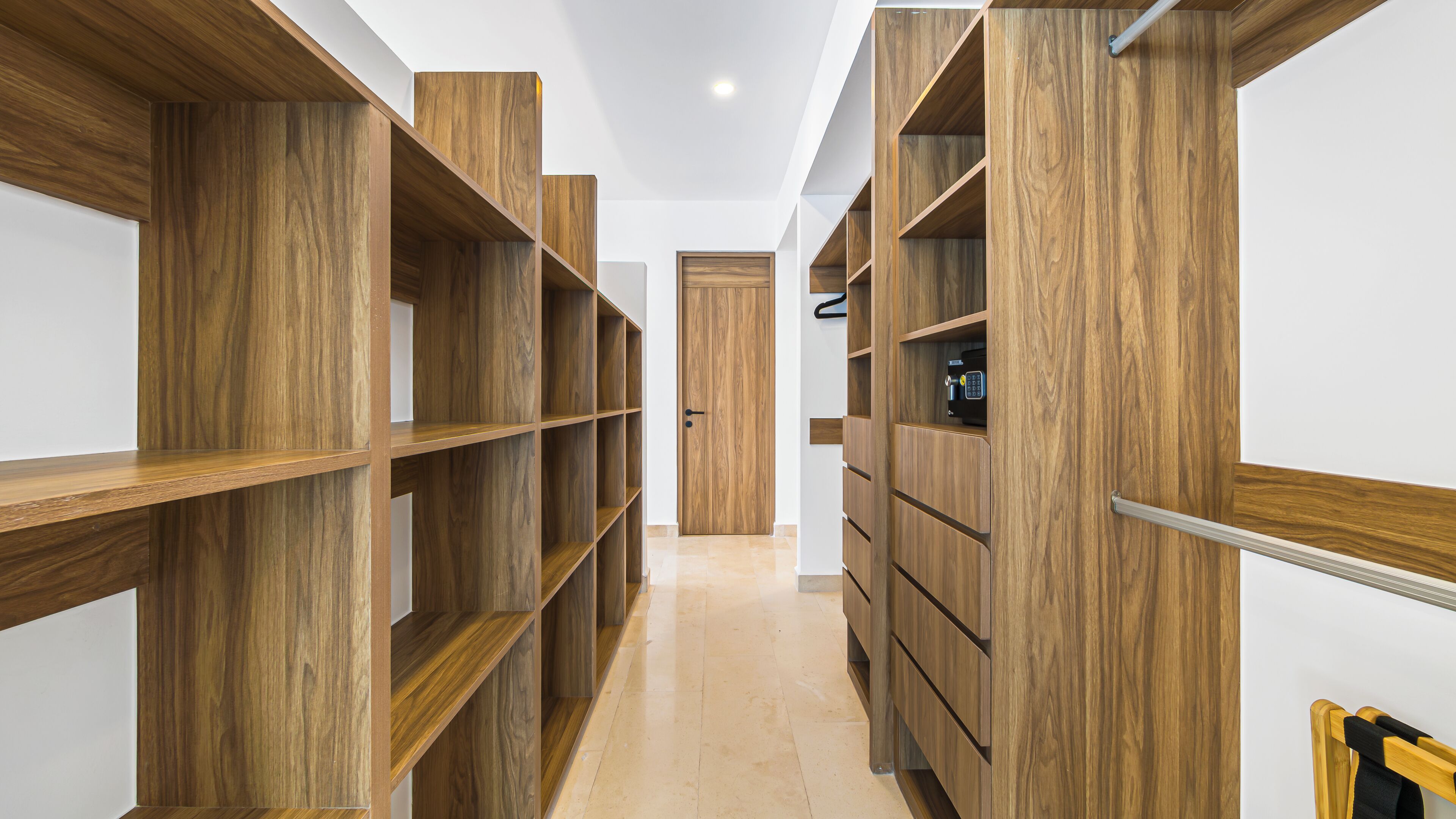 A hallway with wooden shelving units and a door at the end.