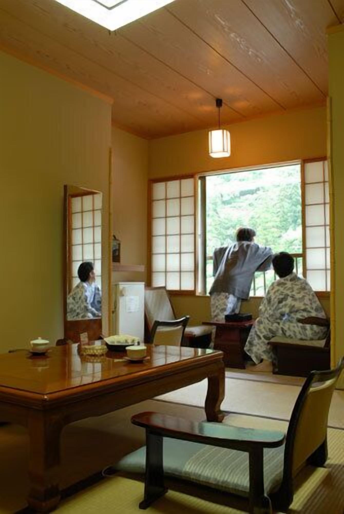 A traditional Japanese room with tatami flooring, a low wooden table, and sliding shoji doors.