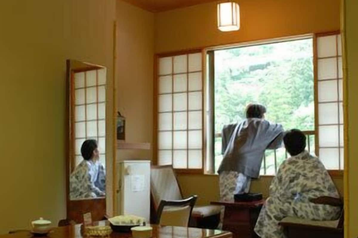 A traditional Japanese room with tatami flooring, a low wooden table, and sliding shoji doors.