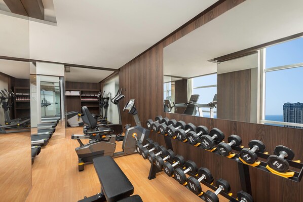 A gym with treadmills, elliptical machines, a bench, and a rack of dumbbells. - Days Hotel By Wyndham Weihai Huoju Eight Street (Weihai)