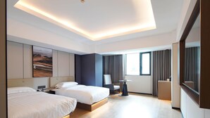 Una habitación de hotel moderna con dos camas, un escritorio, una silla y una mesita.