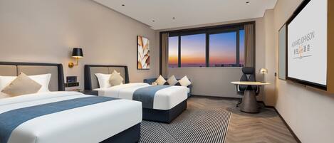 Habitación de hotel con dos camas, un escritorio, una silla, un ventanal grande con vista al atardecer y una pantalla de proyector mostrando 'HOWARD JOHNSON'.