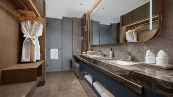 A modern bathroom with a marble countertop, dual sinks, a large mirror, and a robe rack.