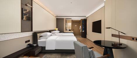 Una habitación de hotel moderna con una cama grande, un escritorio, una silla y un televisor.