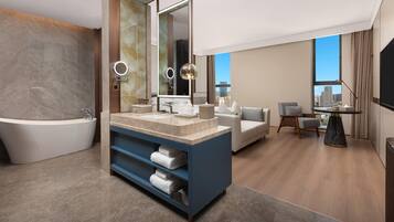 A modern bathroom with a freestanding bathtub, a large mirror, and a vanity with a marble countertop.