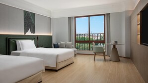 A hotel room with two beds, a balcony with a view, a small table, and a TV. - Wyndham Garden Guangzhou Panyu (Guangzhou)