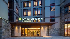 A hotel entrance with a sign reading "WYNDHAM GARDEN" and "温德姆花园酒店". - Wyndham Garden Guangzhou Panyu (Guangzhou)