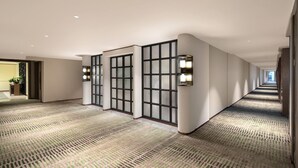A hotel hallway with patterned carpet, recessed lighting, and a view into another room. - Wyndham Garden Guangzhou Panyu (Guangzhou)