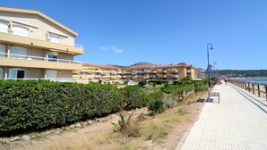 A coastal hotel with multiple balconies, a paved walkway, and a view of the sea. - Apartment in Estartit Near sea Beach (Torroella de Montgrí)