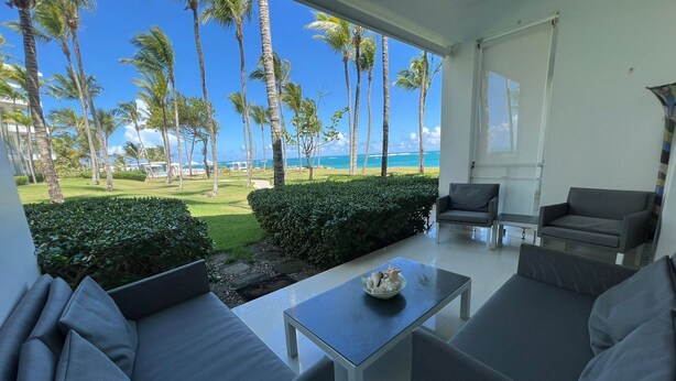 A modern living room with a view of the beach and palm trees. - beach paradise ground floor Cabarete (Cabarete)