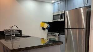 A modern kitchen with a central island, stainless steel appliances, and a microwave above the oven. - beach paradise ground floor Cabarete (Cabarete)