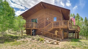 Une cabane en bois dotée d’un balcon, d’un escalier et d’un drapeau américain.