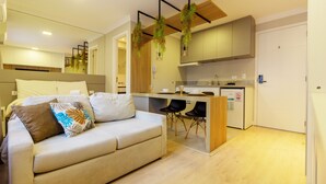Un apartamento moderno con sofá, comedor y cocina.