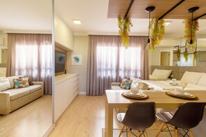 Ein modernes Hotelzimmer mit Essbereich, einer Couch und einem Bett.