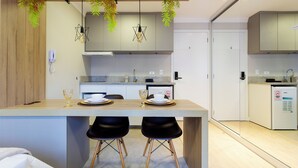 Una cocina moderna con una isla central, taburetes negros y lámparas colgantes.