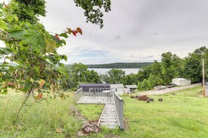 A wooden deck leading to a house with a view of a lake and hills in the background. - Walk to Norfork Lake: Guest House in Henderson (Henderson)