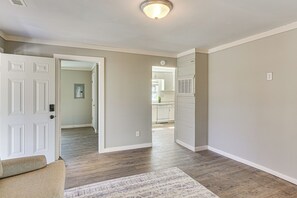 A hallway with a beige wall, a white door, and a patterned rug. - Close to Shops, Eats & Hospital: Roxboro Retreat (Roxboro)
