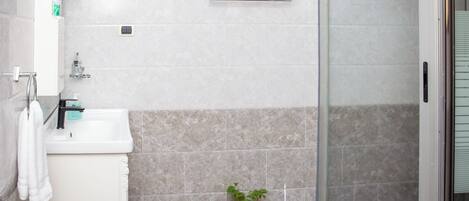 A bathroom with a sink, towel rack, and a potted plant.