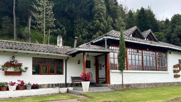 Ett traditionellt hus med ett tak täckt av tegelpannor, träfönster och en grundmur av sten.
