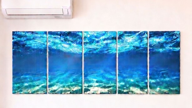 A room with a sofa, patterned pillows, a table with a tablecloth, and a wall-mounted artwork. - Room-private Blue Apartment at Palma de (Sant'Antioco)