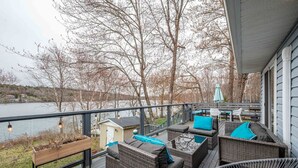 Una terrazza con mobili in vimini e vista su un lago.