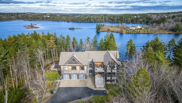 A large house with a driveway, surrounded by trees and a lake. - Peaceful Retreat on Schmidt Lake (Hammonds Plains)