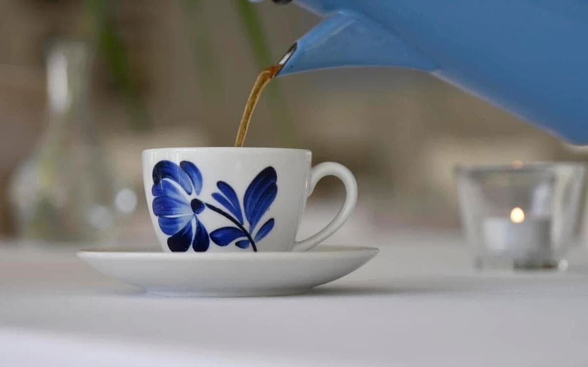 A cup with a floral design on a saucer.