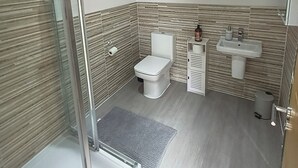 A modern bathroom with a shower, toilet, and sink. - Large Guest Room with Kingsize Bed & Private Bathroom (Roundswell)