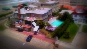 Une maquette d’un immeuble à plusieurs étages, doté d’une piscine, d’un parking et offrant une vue sur l’océan.
