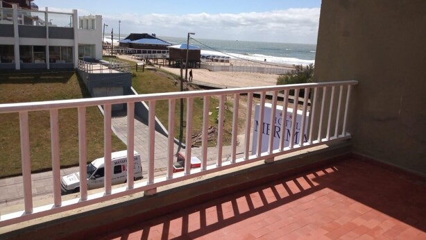 Un balcon avec vue sur la plage et l’océan.