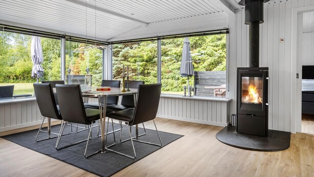 Una habitación moderna con una mesa de comedor, sillas y una estufa de leña.