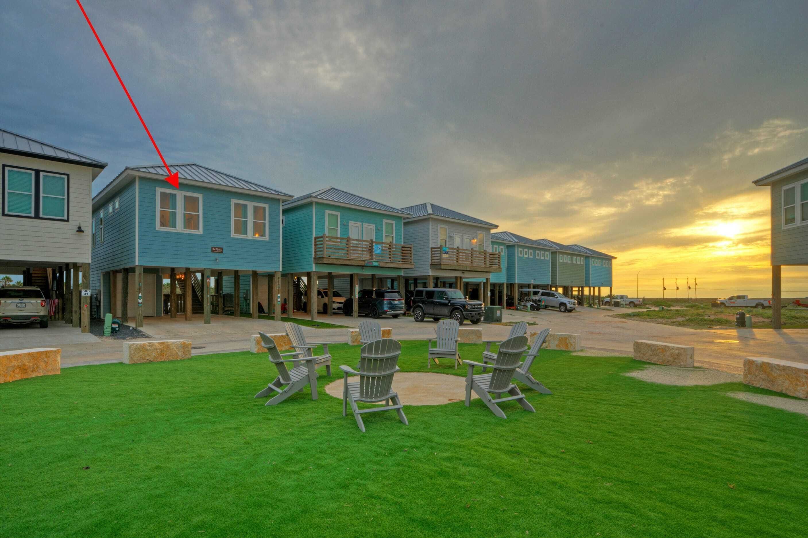 Une rangée de charmantes maisons de vacances en bord de mer, dotées d’un espace extérieur aménagé et offrant une vue sur le coucher de soleil.
