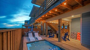 A pool area with lounge chairs, a hot tub, and a wooden deck. - Private Pool, Fire Pit, Beach Boardwalk Access, Views The Madison by Avantstay (Port Aransas)