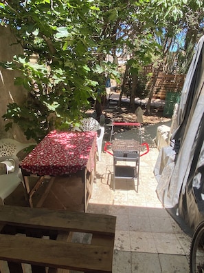 A patio area with a table, chairs, and a grill.