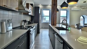 A modern kitchen with a central island, stainless steel appliances, and pendant lighting. - Sublime 3BR/3BA condo with Parking in the Heart of Old Montreal (Montréal)