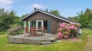 A small wooden cabin with a deck, a dining table, and chairs. - Gorgeous home in Glesborg with WiFi (Glesborg)