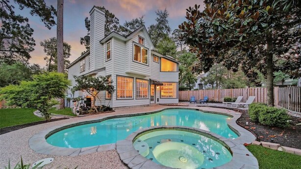 A two-story house with a swimming pool and hot tub. - The Woodlands Gem- Heated Pool+Spa, EV Charging, Baby Crib, Ping Pong, Grill (The Woodlands)