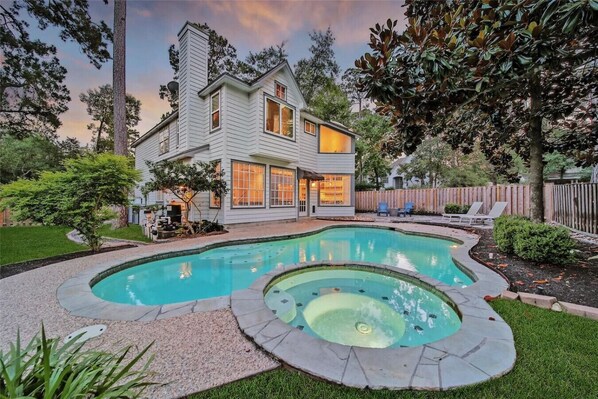 Una casa de dos pisos con piscina y jacuzzi.