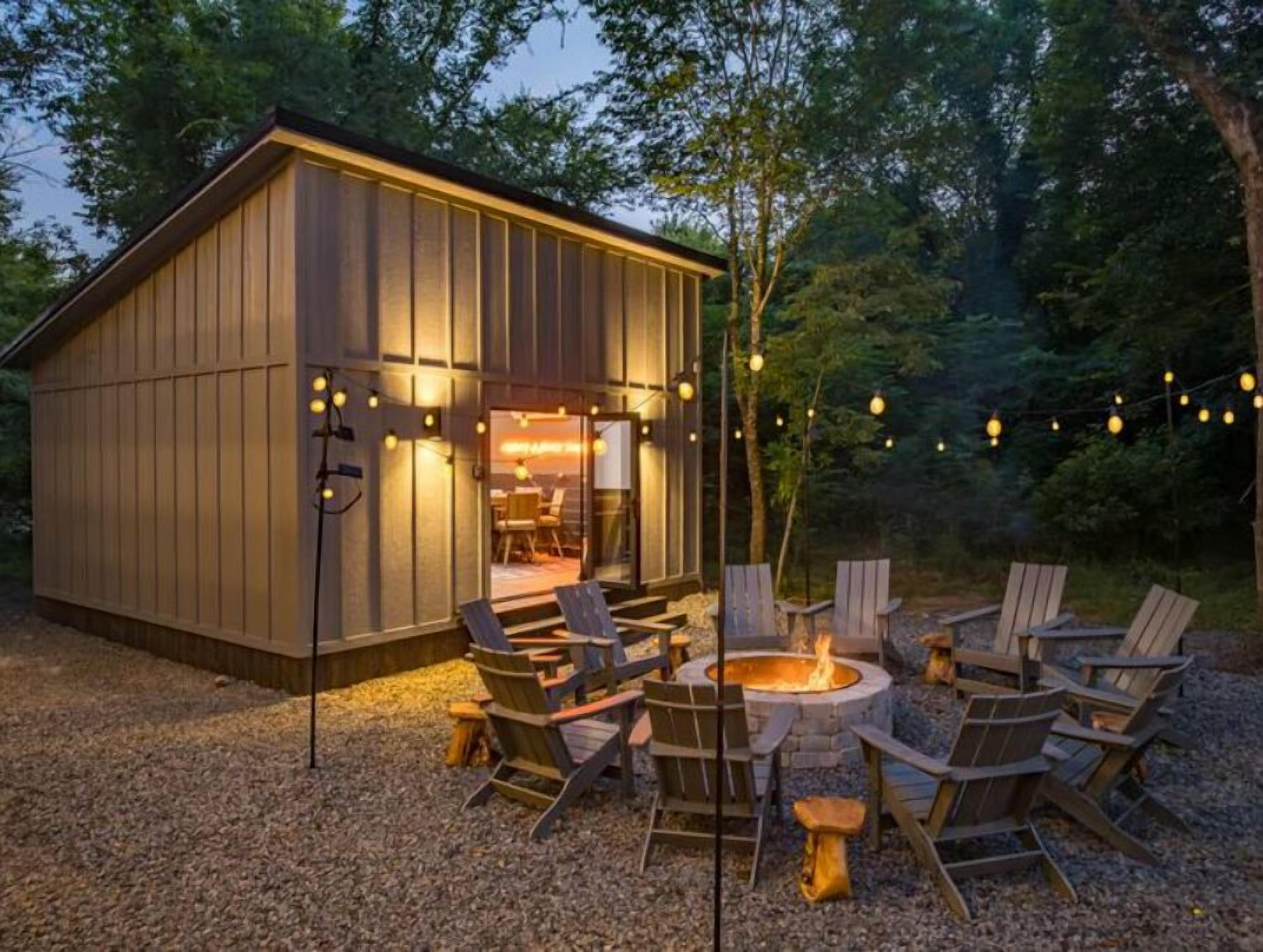 A wooden cabin with a fire pit and outdoor seating.