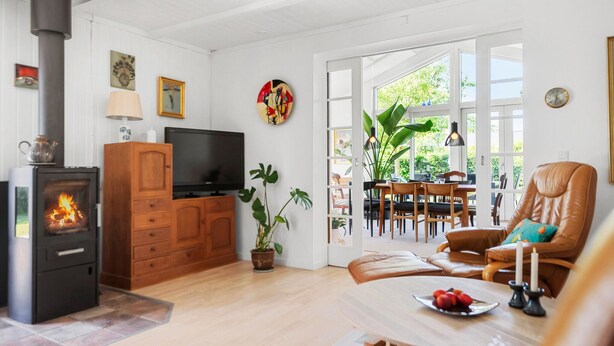 Ein gemütliches Wohnzimmer mit Kamin, Fernseher und Essbereich mit Tisch und Stühlen.